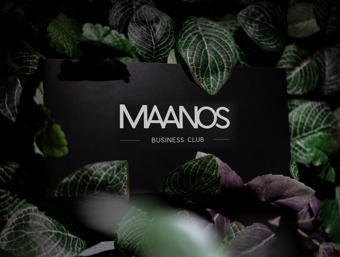 Carte MAANOS Business Club sur fond de feuillage, pénombre